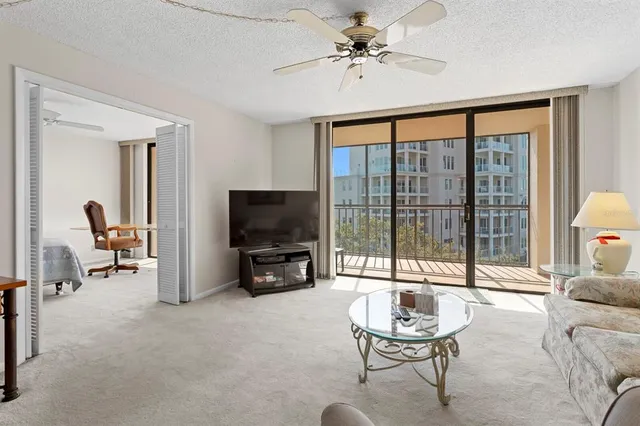 a living room with furniture a flat screen tv and a large window