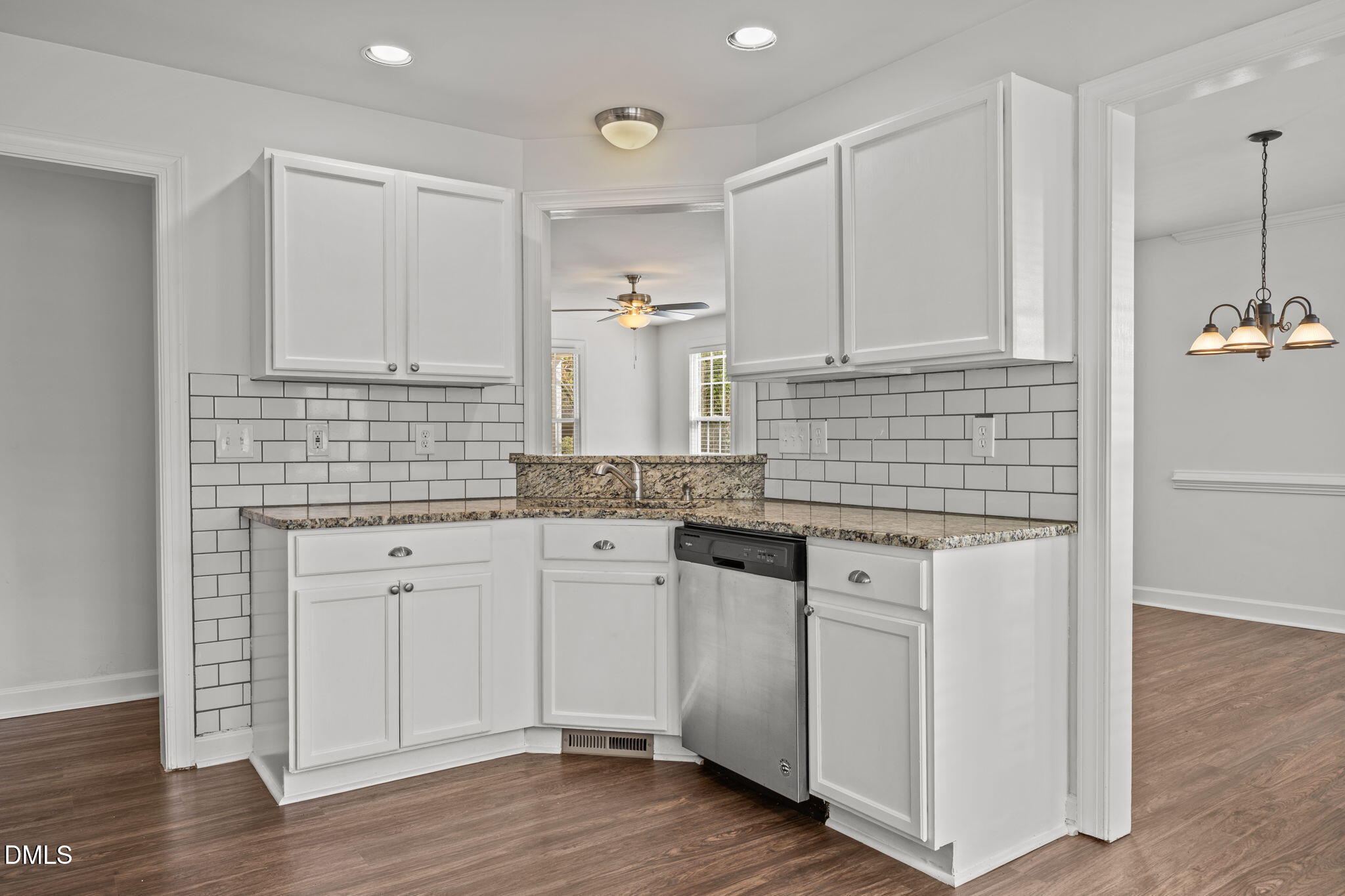 9220 Pennythorne Court Raleigh, NC 27615 - Photo 18 of 49 a kitchen with stainless steel appliances granite countertop a sink stove and white cabinets with wooden floor