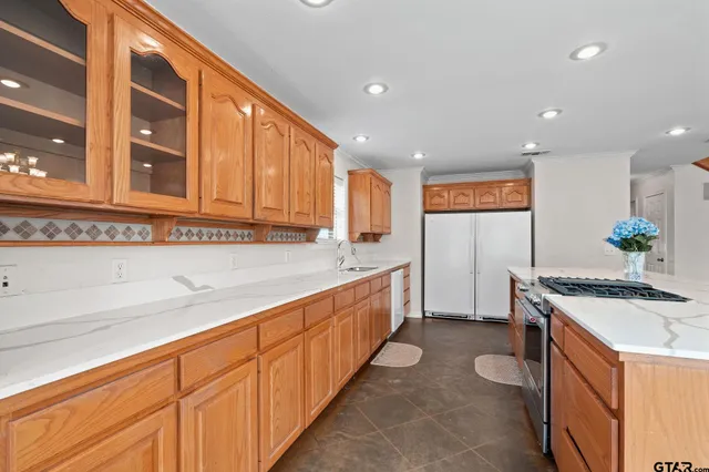 a kitchen with granite countertop sink and cabinets