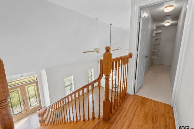 a view of a hallway with wooden floor and stairs
