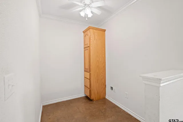 an empty room with chandelier fan