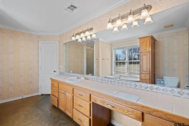 a spacious bathroom with double vanity and a mirror