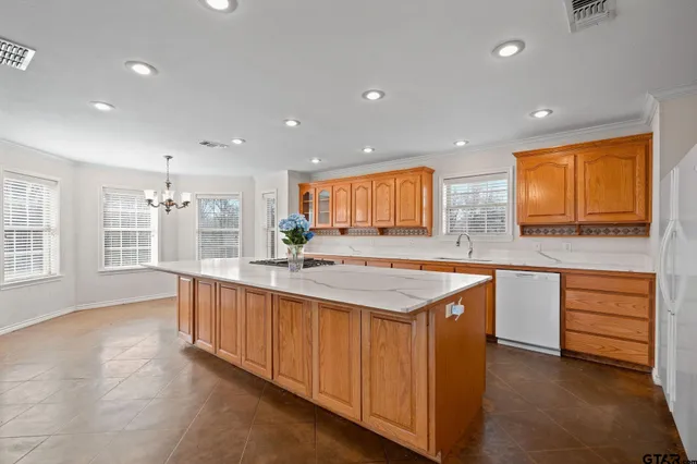a large kitchen with stainless steel appliances granite countertop a large counter top and a sink