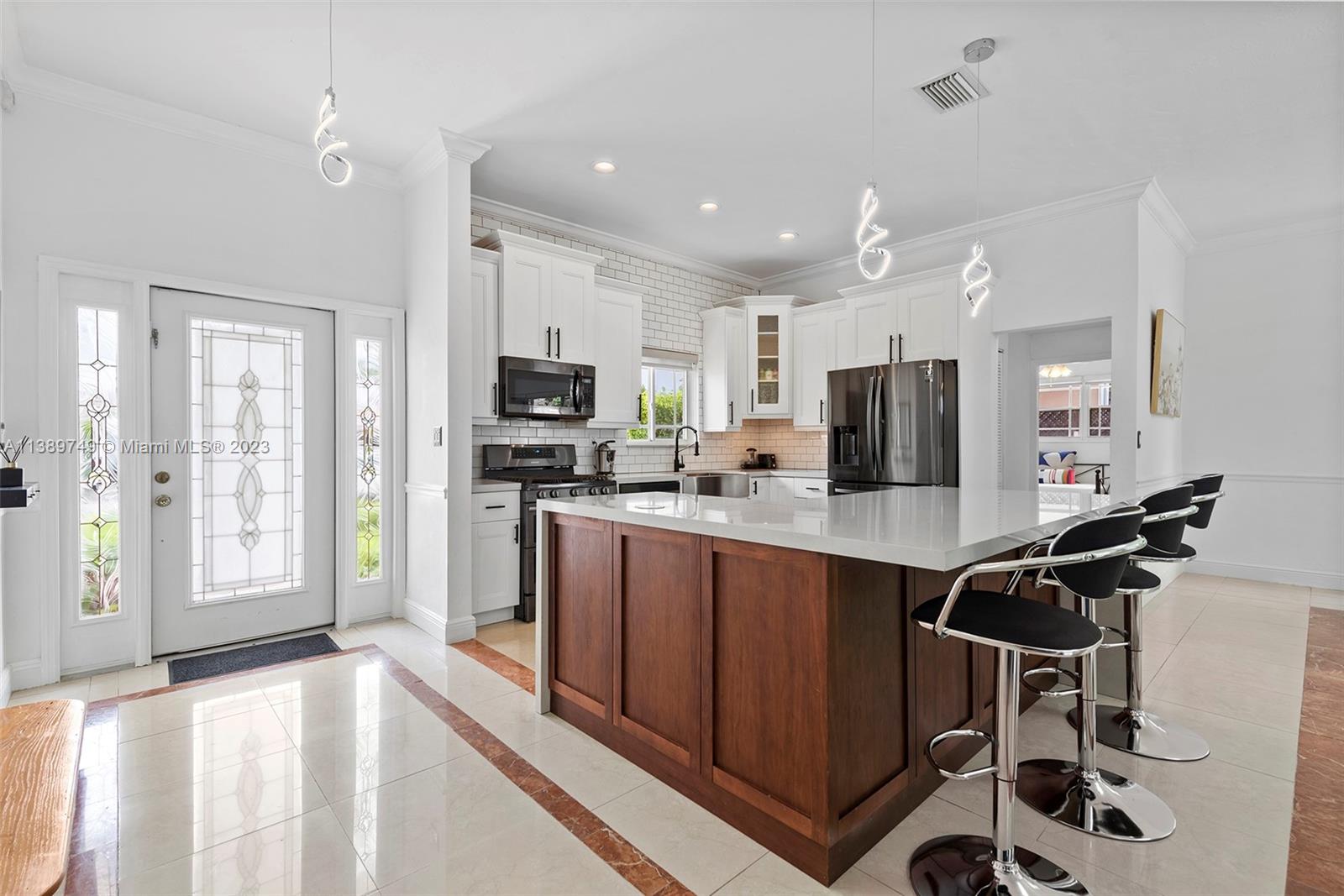 2201 Southwest 84th Avenue Miami, FL 33155 - Photo 15 of 33 a kitchen with stainless steel appliances granite countertop a refrigerator a sink a stove and white cabinets with wooden floor