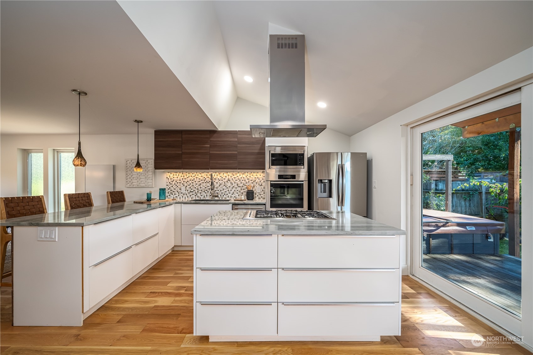 3919 Southwest Monroe Street Seattle, WA 98136 - Photo 8 of 40 a large white kitchen with kitchen island a large counter top space a sink stainless steel appliances and cabinets