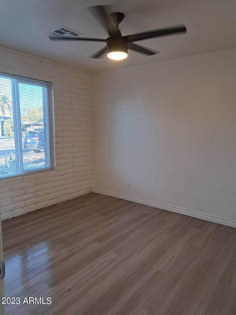6713 East Cheery Lynn Road, Unit 4 Scottsdale, AZ 85251 - Photo 7 of 12 a view of an empty room with wooden floor and a window