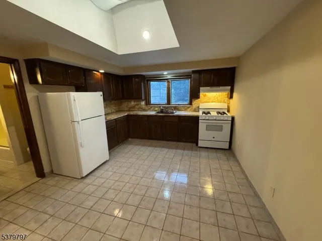 a kitchen with granite countertop a refrigerator and a stove