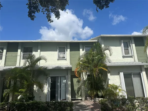 a front view of a house with plants