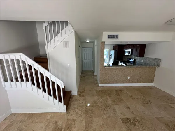 a view of a room with stairs and a wooden floor