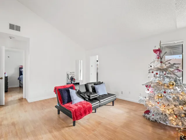 an empty room with wooden floor fireplace and windows