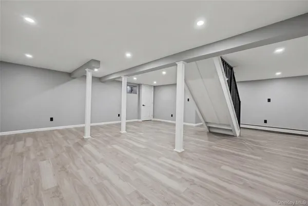 an empty room with wooden floor and window