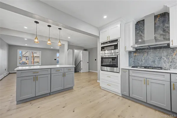 a large kitchen with kitchen island a sink stainless steel appliances and cabinets
