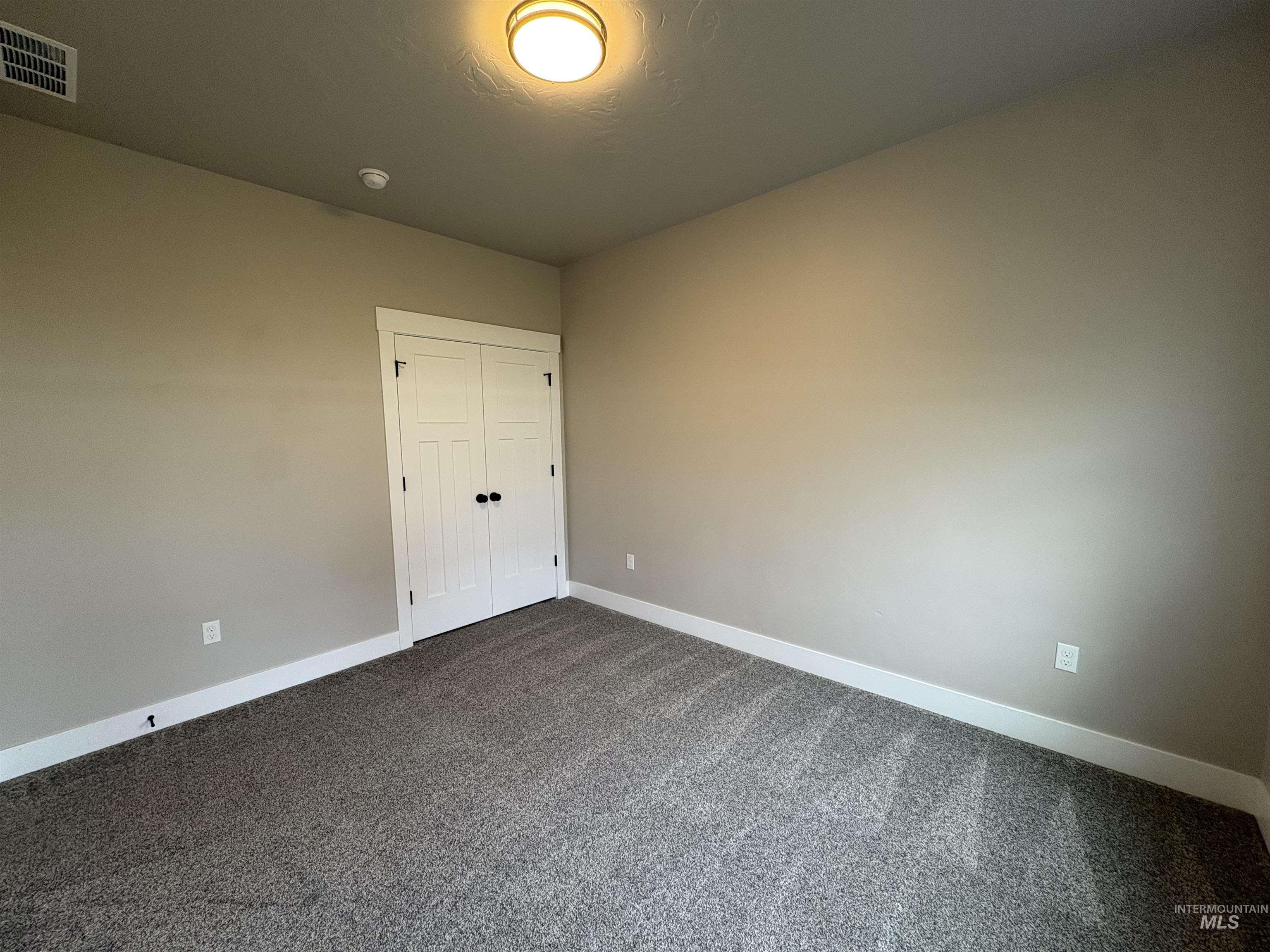 2184 Austin Way Fruitland, ID 83619 - Photo 19 of 34 Unfurnished bedroom with dark carpet and a closet