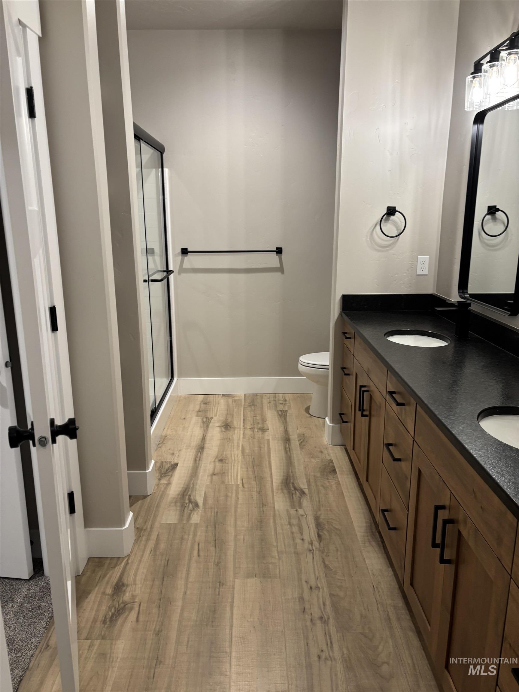 2184 Austin Way Fruitland, ID 83619 - Photo 23 of 34 Bathroom featuring a shower stall, double vanity, and light wood finished floors