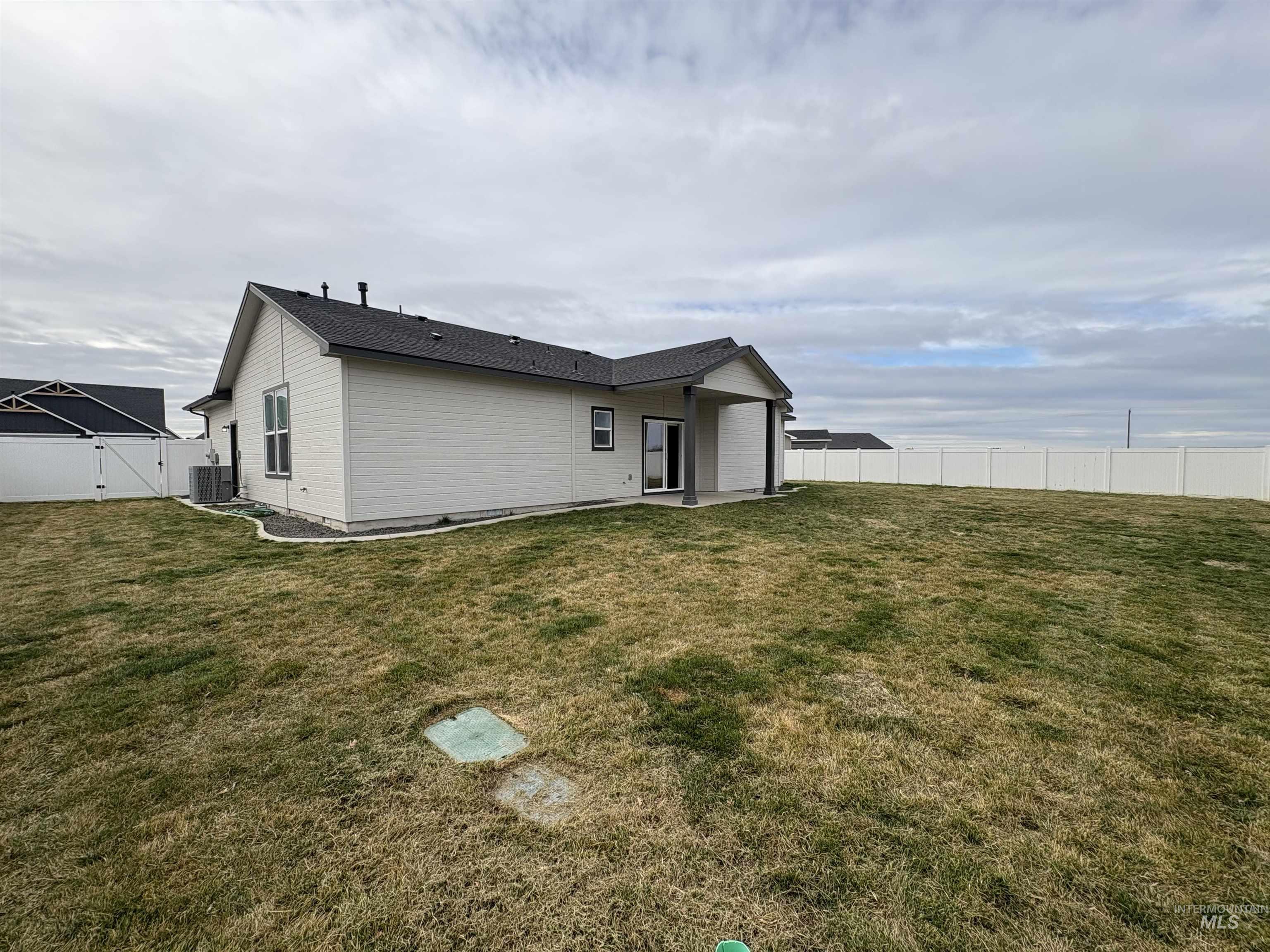 2184 Austin Way Fruitland, ID 83619 - Photo 29 of 34 Back of property with a fenced backyard, a gate, and a patio area