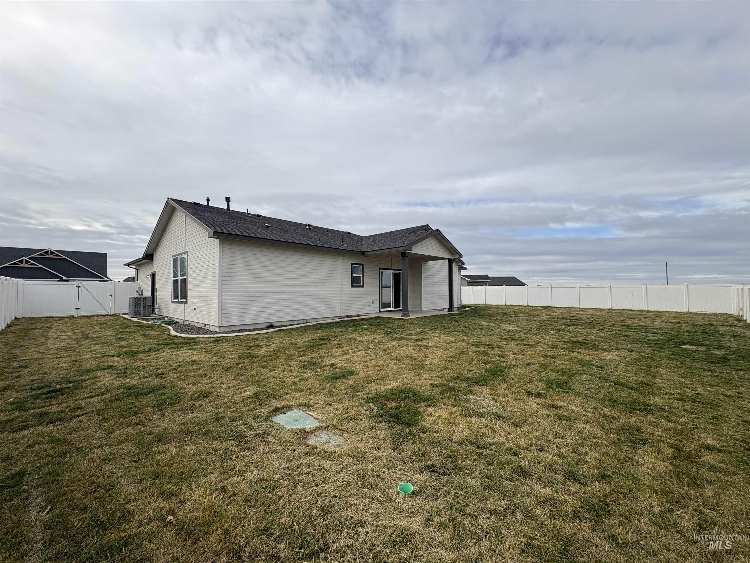 2184 Austin Way Fruitland, ID 83619 - Photo 30 of 34 Back of property with a gate, a fenced backyard, and a patio area
