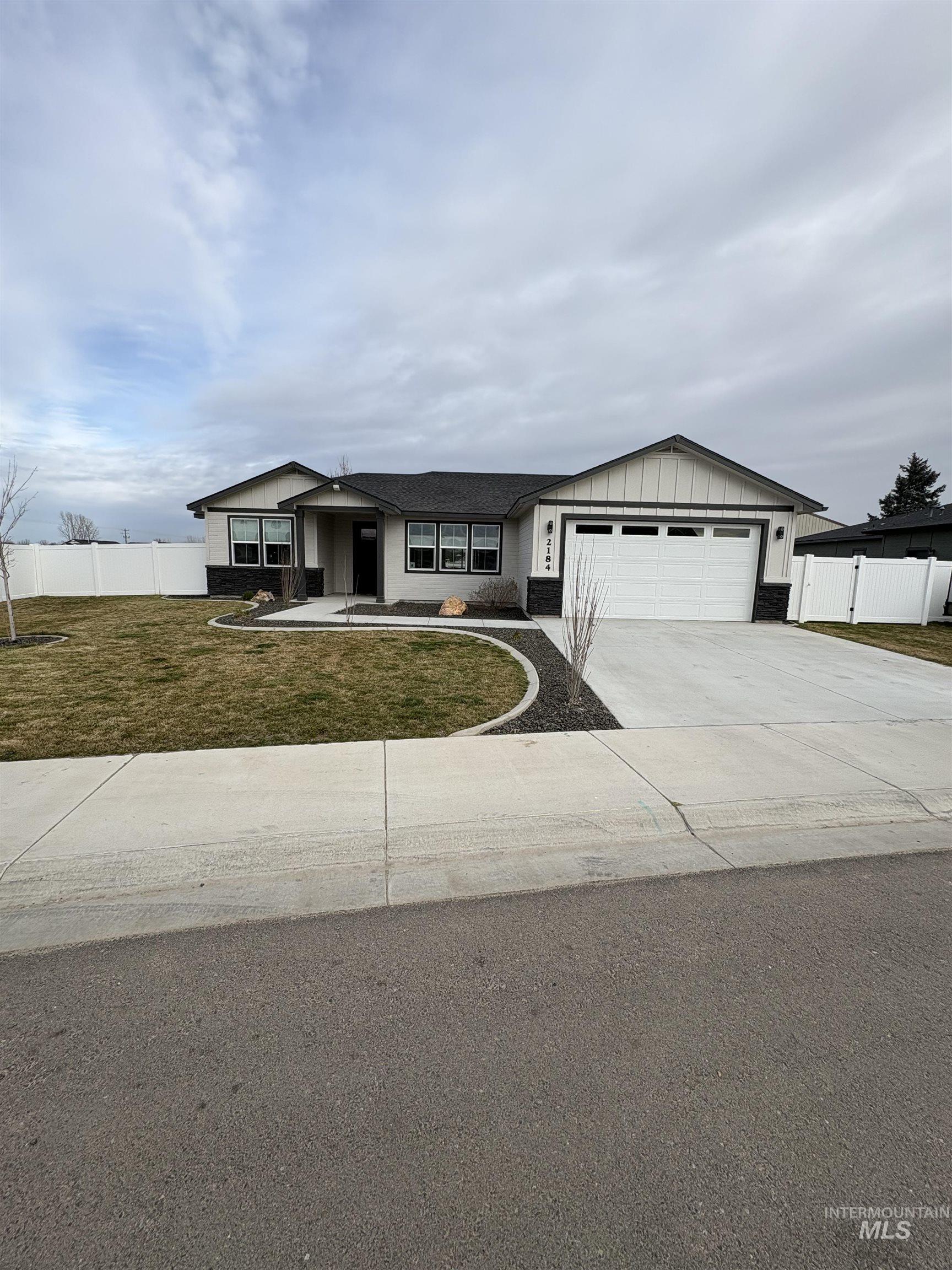 2184 Austin Way Fruitland, ID 83619 - Photo 4 of 34 Single story home with driveway, an attached garage, board and batten siding, and covered porch