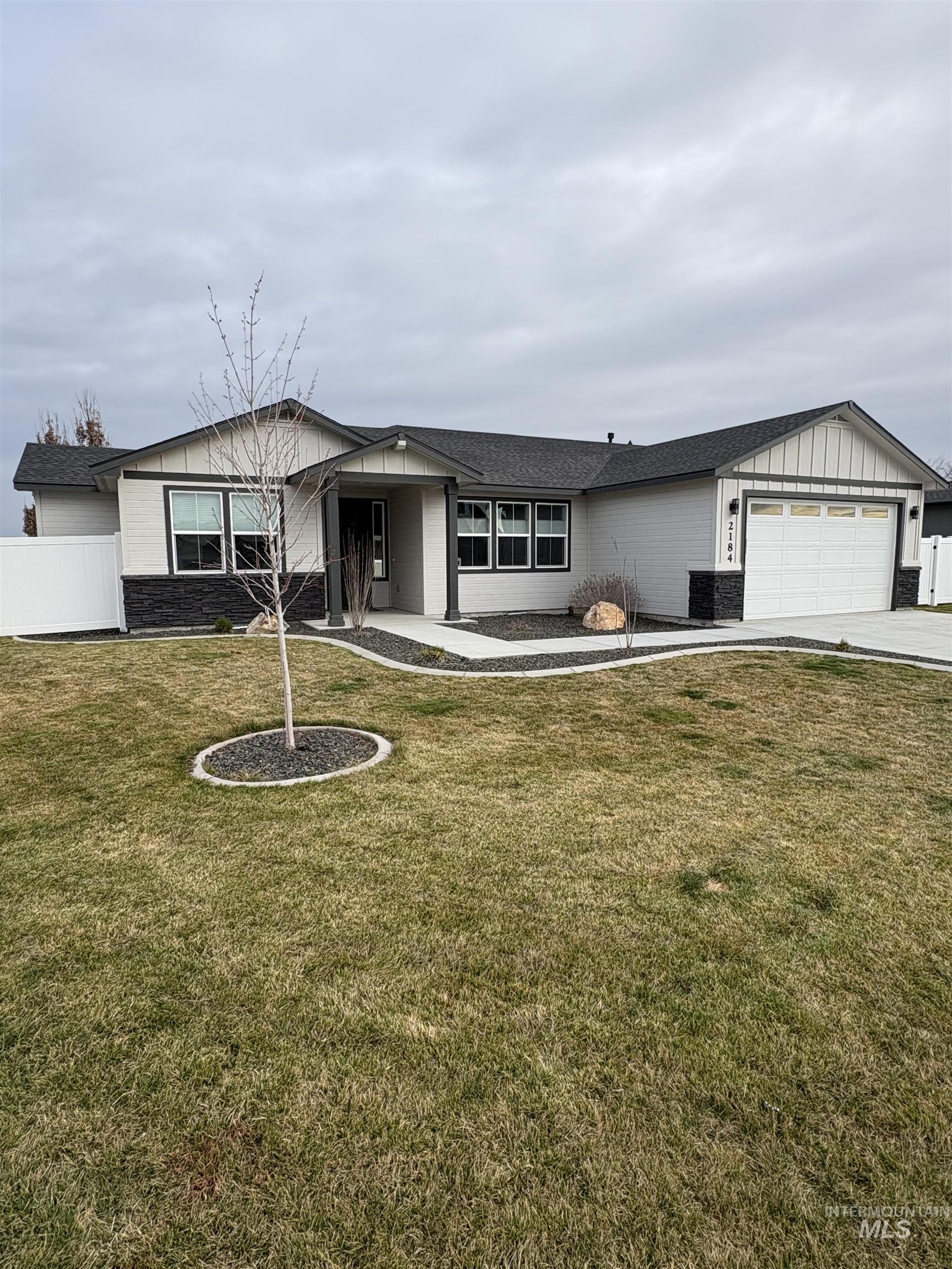 2184 Austin Way Fruitland, ID 83619 - Photo 5 of 34 Ranch-style house featuring stone siding, board and batten siding, a garage, driveway, and a porch