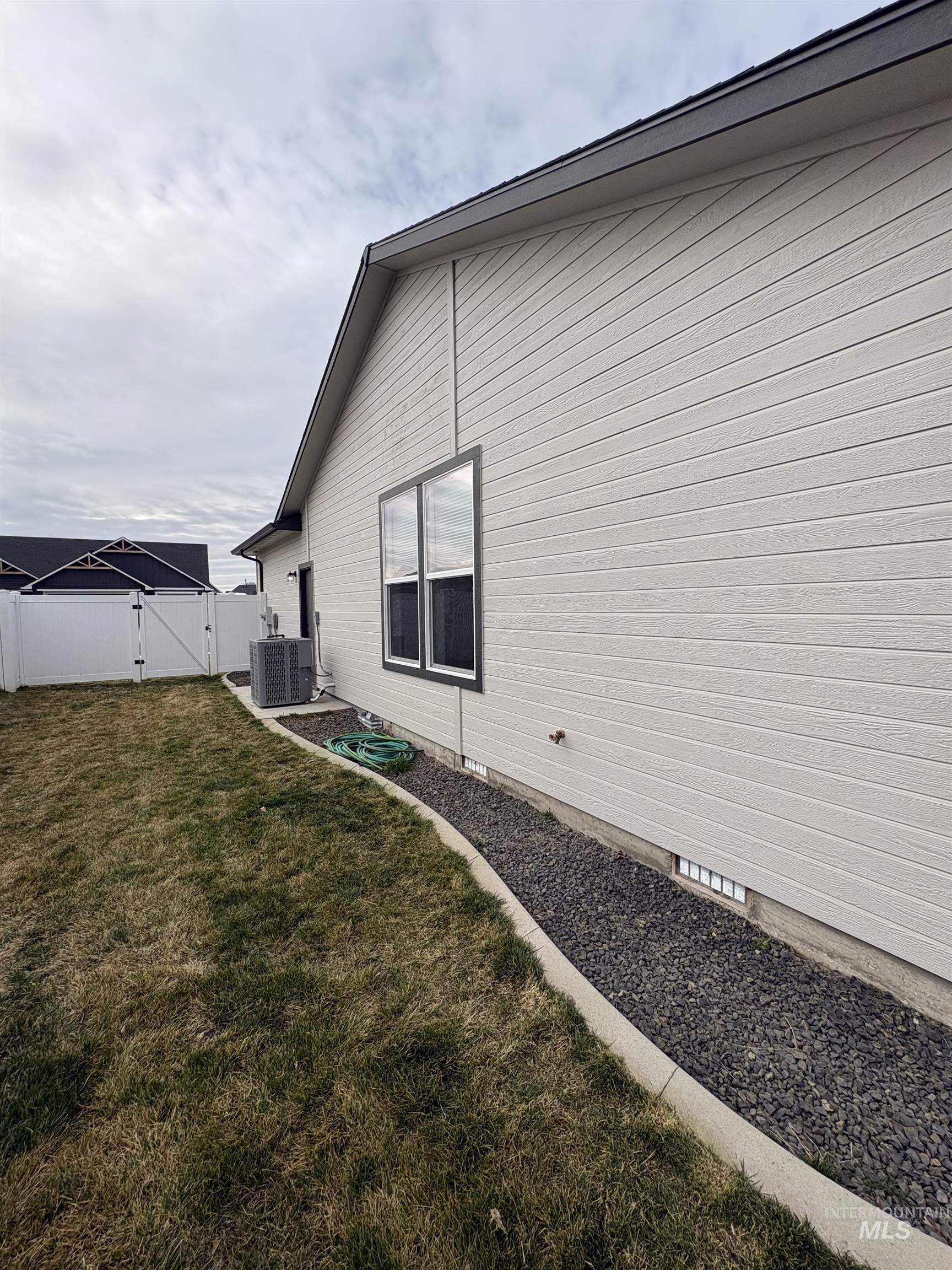 2184 Austin Way Fruitland, ID 83619 - Photo 8 of 34 View of home's exterior featuring a gate and a fenced backyard