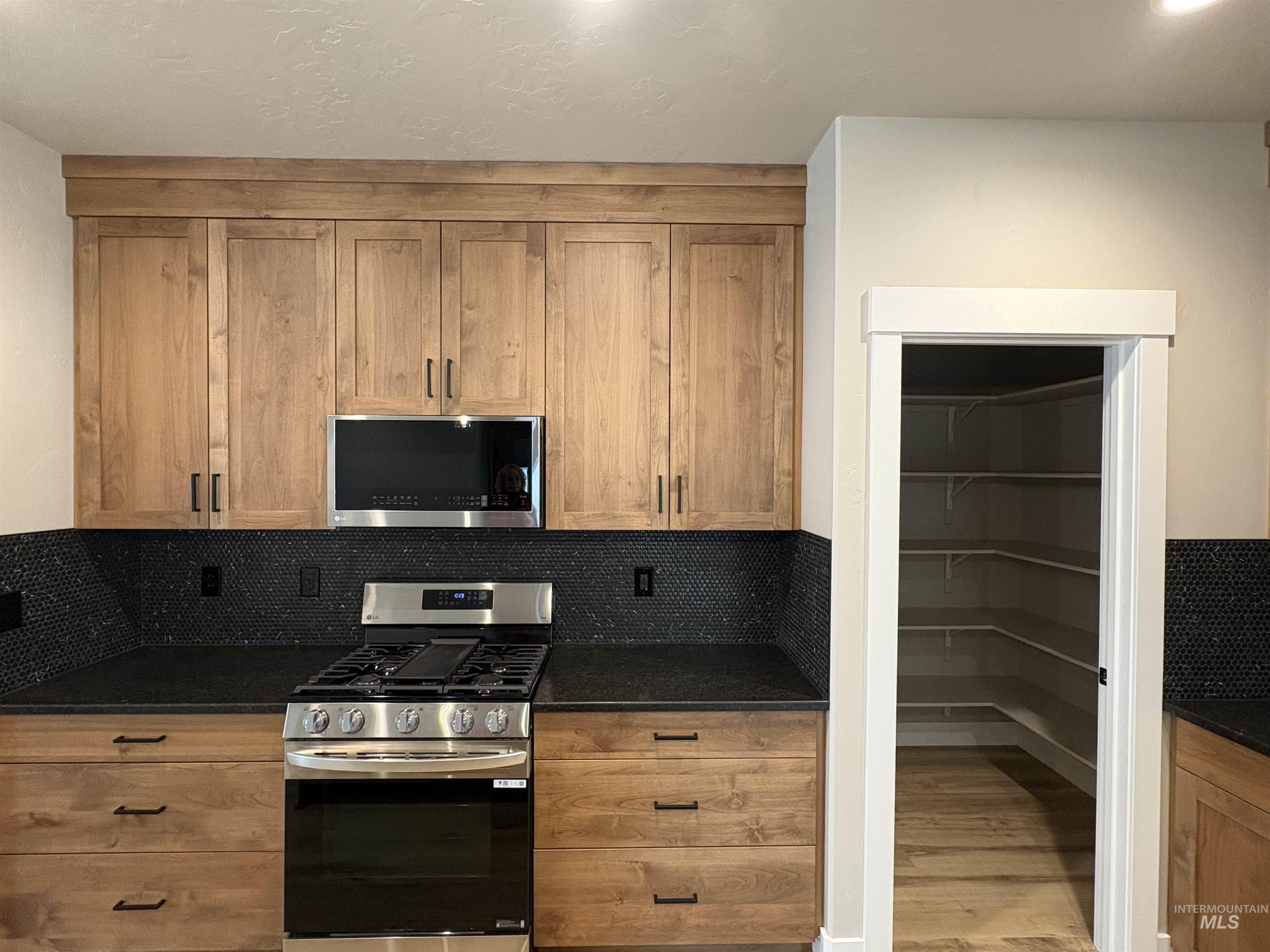 2184 Austin Way Fruitland, ID 83619 - Photo 10 of 34 Kitchen featuring stainless steel appliances, dark stone counters, and wood finish cabinets