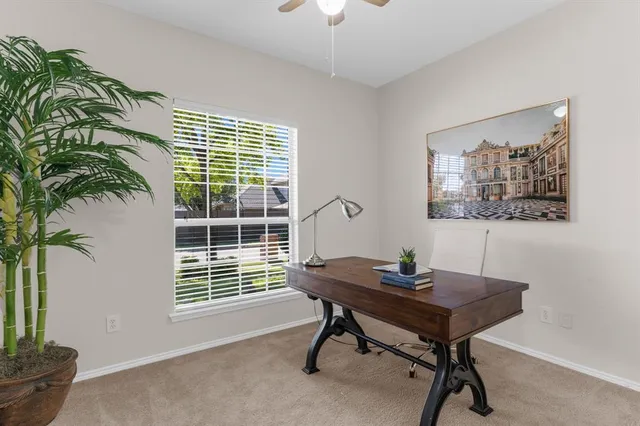 a view of a workspace with furniture and a window