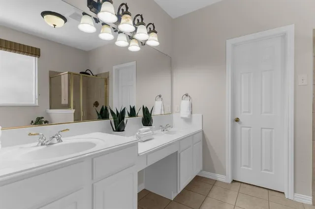 a bathroom with a sink a large mirror and a light fixture