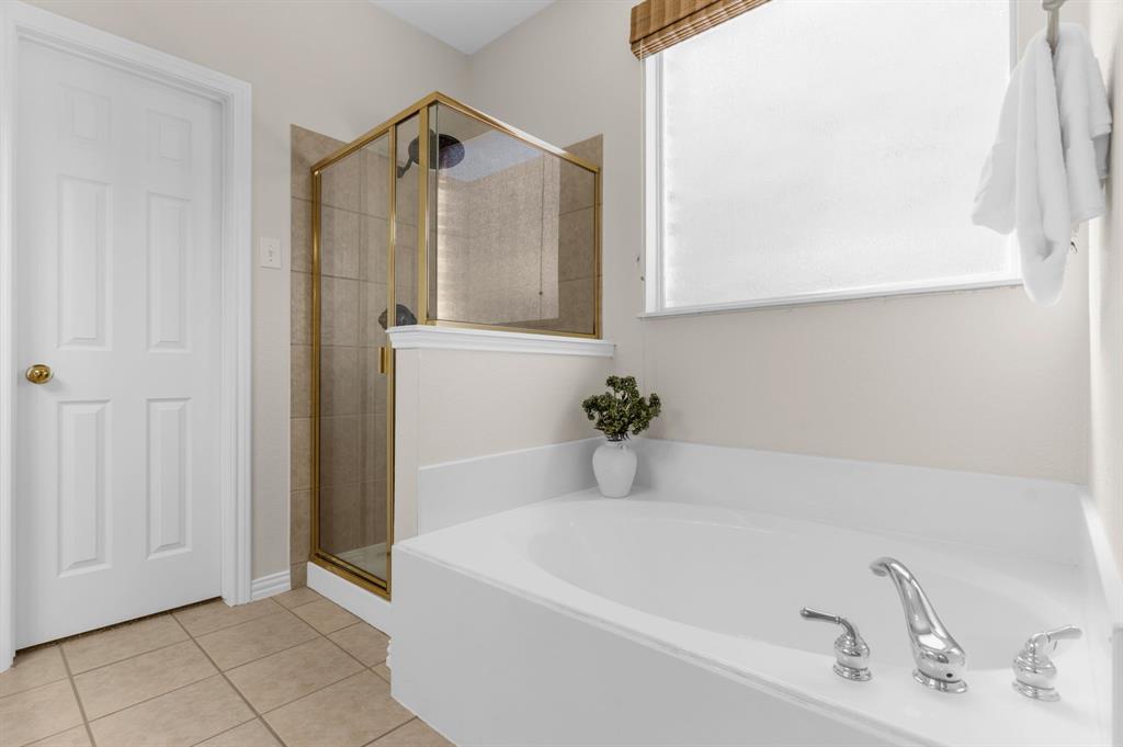4607 Forest Park Road Plano, TX 75024 - Photo 17 of 40 a bathroom with a tub and mirror
