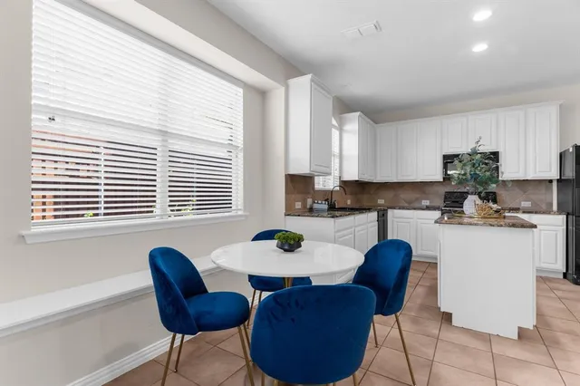 a kitchen with a table chairs and a window