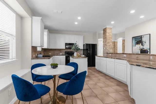 a kitchen with stainless steel appliances granite countertop a sink a stove a kitchen island and chairs