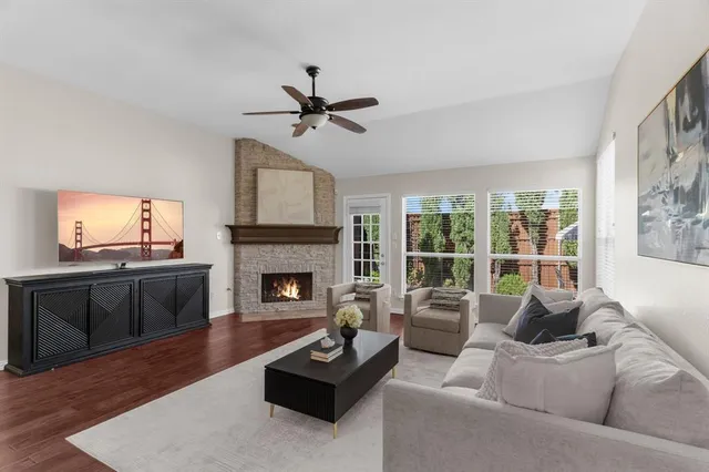 a living room with furniture a fireplace a flat screen tv and a large window