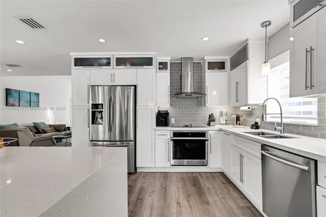 a kitchen with a refrigerator a sink and a stove top oven