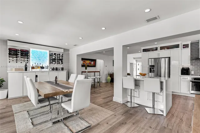 a living room with furniture a large window and wooden floor