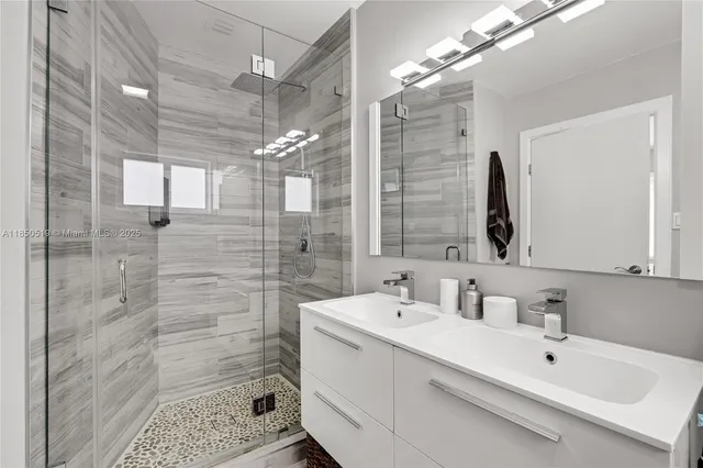 a bathroom with a sink mirror and shower