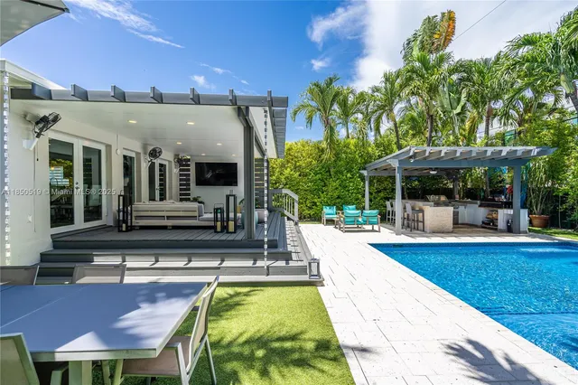 a view of a house with swimming pool and sitting area