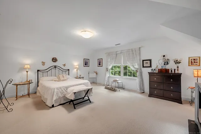 a bedroom with a bed lamp and dresser