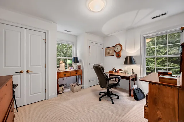 a view of a workspace with furniture and a window