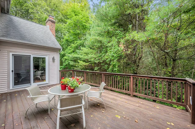 a balcony with wooden floor and outdoor seating