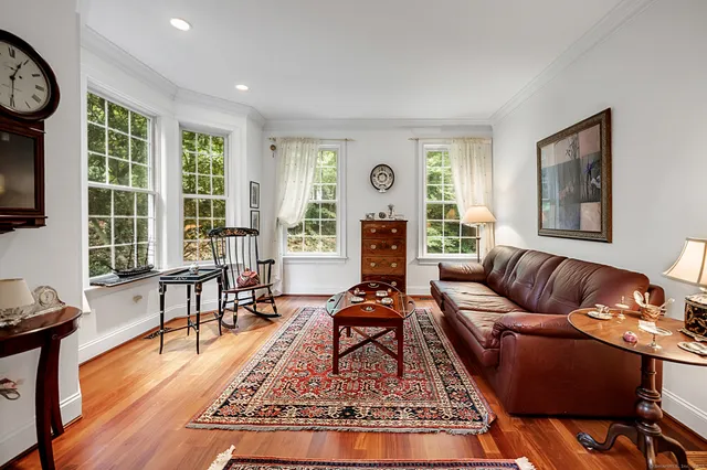 a living room with furniture a rug a window and wooden floor