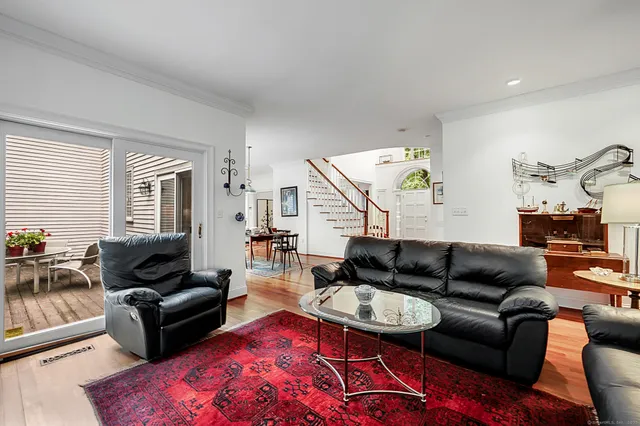 a couch sitting in a living room with furniture and a large window
