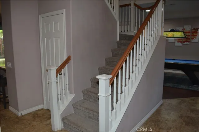 a view of staircase with lots of frames on wall and wooden floor