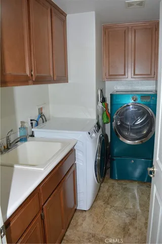 a utility room with a sink and a washer dryer