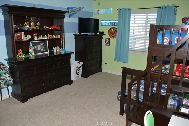 a bedroom with a bed a flat screen tv and a window