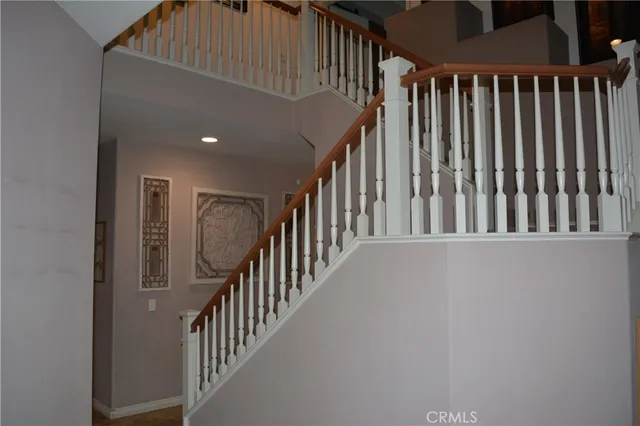 a view of staircase with railing and white walls