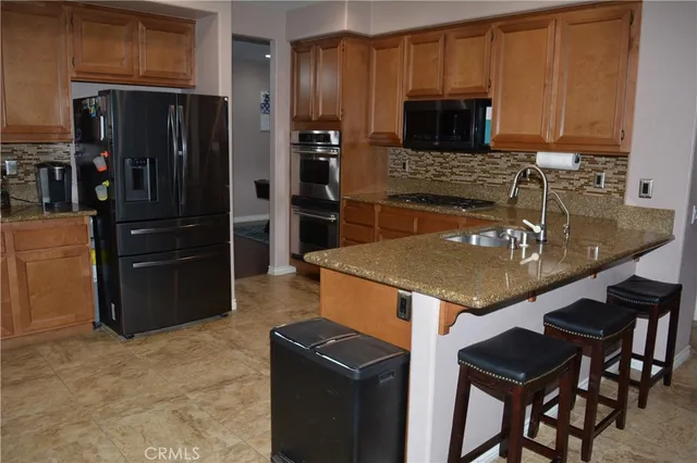 a kitchen with stainless steel appliances granite countertop a stove refrigerator and a microwave