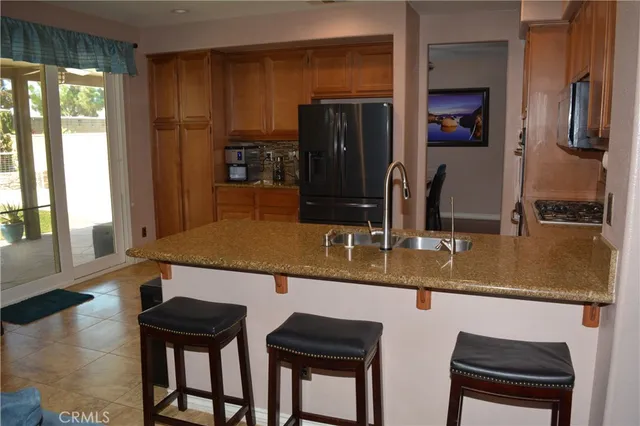 a kitchen with stainless steel appliances granite countertop a sink and a refrigerator