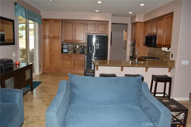 a large kitchen with stainless steel appliances kitchen island granite countertop a refrigerator and a stove