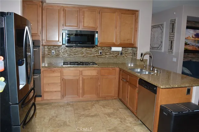 a kitchen with stainless steel appliances granite countertop a refrigerator stove and sink