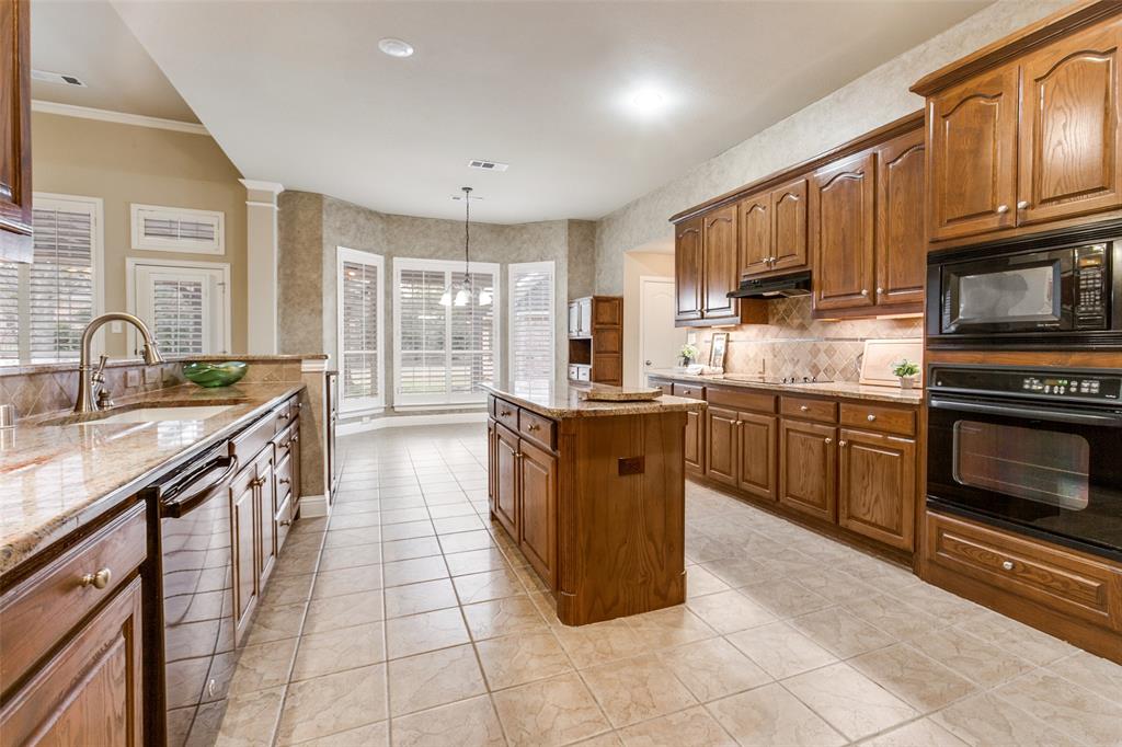 6027 Rathbone Drive Parker, TX 75002 - Photo 2 of 39 a large kitchen with stainless steel appliances granite countertop a stove top oven a sink dishwasher a dining table and chairs with wooden cabinets