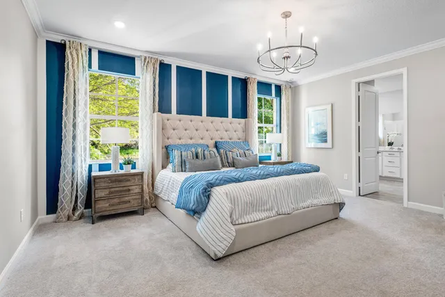 a spacious bedroom with a bed and a chandelier