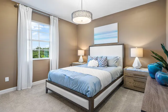 a bedroom with a bed chandelier and a window